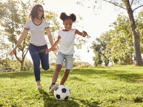 girl playing soccer with her mom