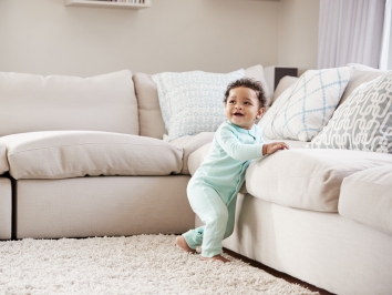 baby leaning on couch