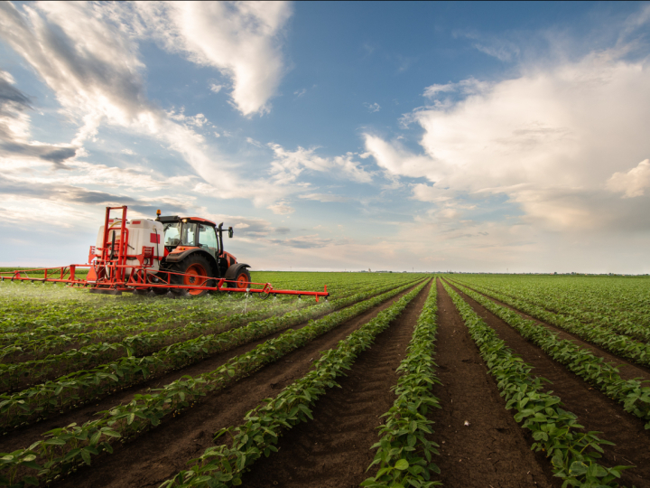 tractor spraying pesticides on crops